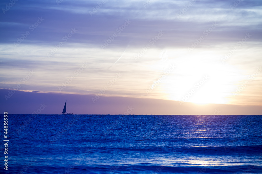 A photo of a sail boat in sunset