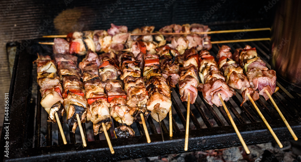 Grilling meat skewers  on natural charcoal barbecue grill.