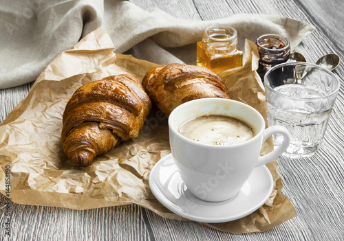 Coffee cup with croissants for breakfast meal.Morning coffee