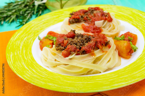 Pasta nest tagliatelle with bolognese sauce on a plate.