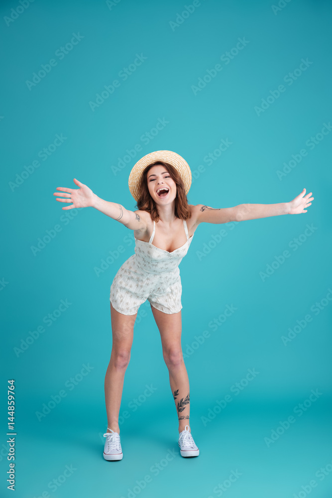Young summer girl wearing hat and standing with outstretched hands Young summer girl wearing hat and standing with outstretched hands