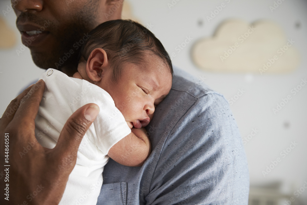 Close Up Of Father Holding Newborn Baby Son In Nursery Close Up Of Father Holding Newborn Baby Son In Nursery