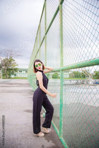 Fashion model Asian women Standing Poses and wear Black shirt. Short hair girl And wear sunglasses