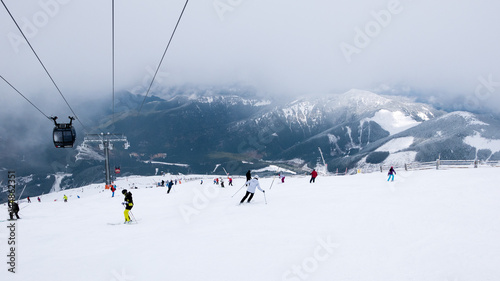 Cable car and skiers on the slope in ski resort Chopok in Slovakia. Tatra lower mountains. photo