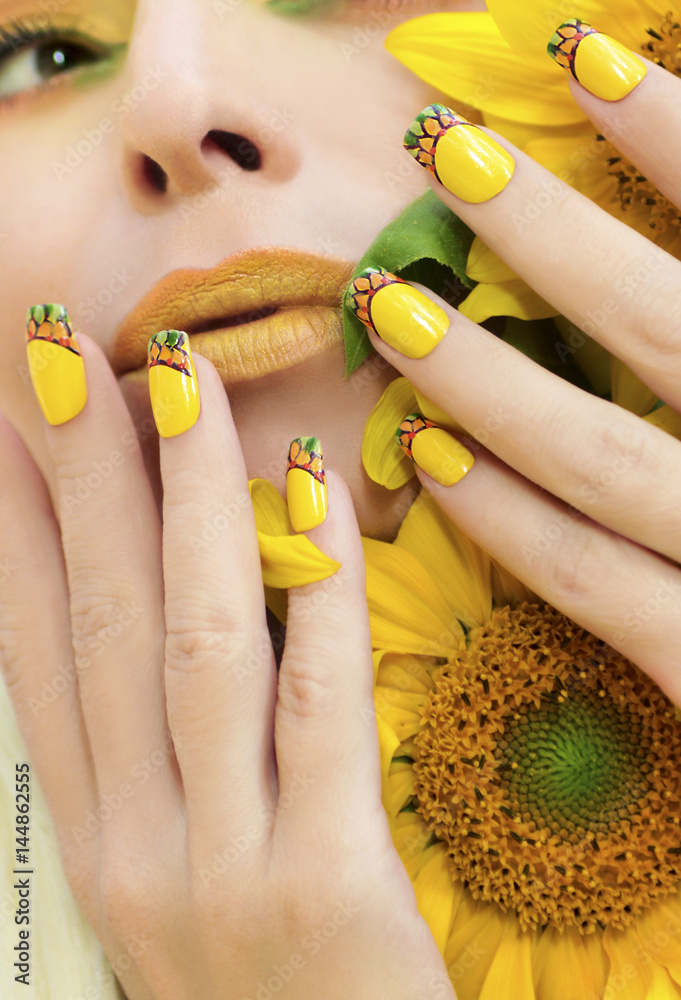 Summer yellow makeup and manicure with a design on the nails on