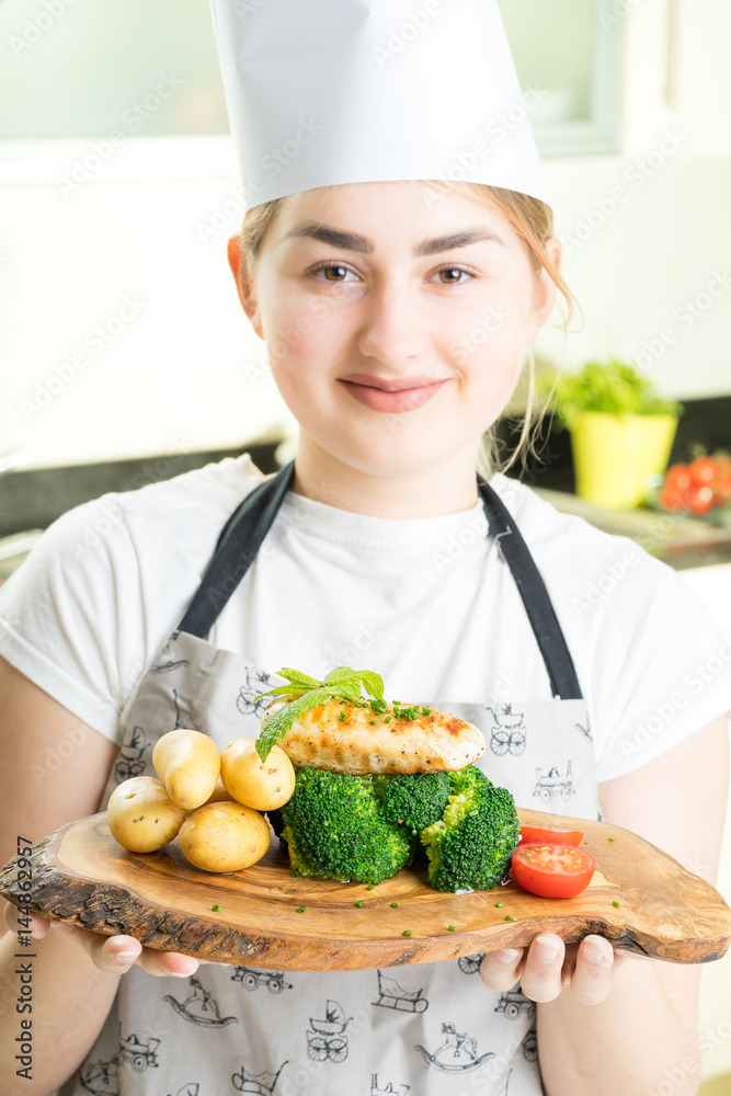 concentrated female chef garnishing food in the kitchen concentrated female chef garnishing food in the kitchen
