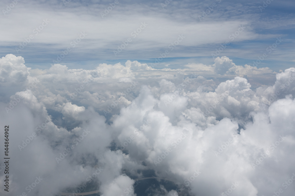 Aerial view on clouds and blue sky from airplane window