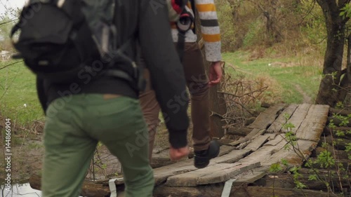 Wallpaper Mural company of tourists with a backpack passes through a wooden bridge. slow motion Torontodigital.ca