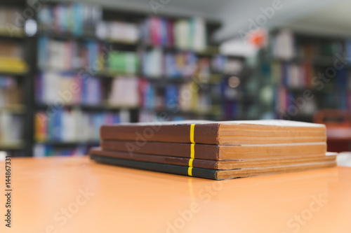 A stack of old books on table with blur book in library, education background