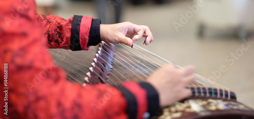 hand of man playing Guzheng.The guzheng or gu zheng, also simply called zheng, is a Chinese instrument photo