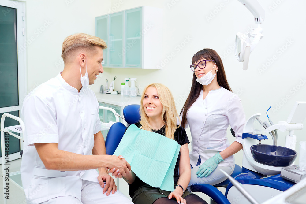 Obraz premium The dentist shakes hands with patient after dental treatment.