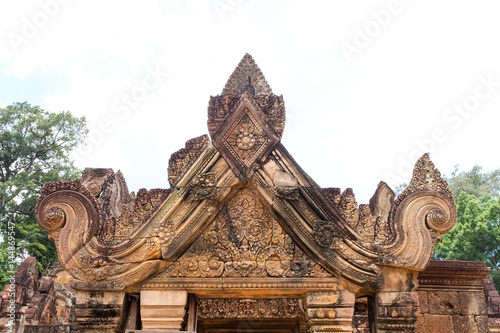 Ancient isosceles pink stone Carving of kala, mythical creature representative of time and of the god Siva in Banteay Srei, Siem reap, Cambodia.