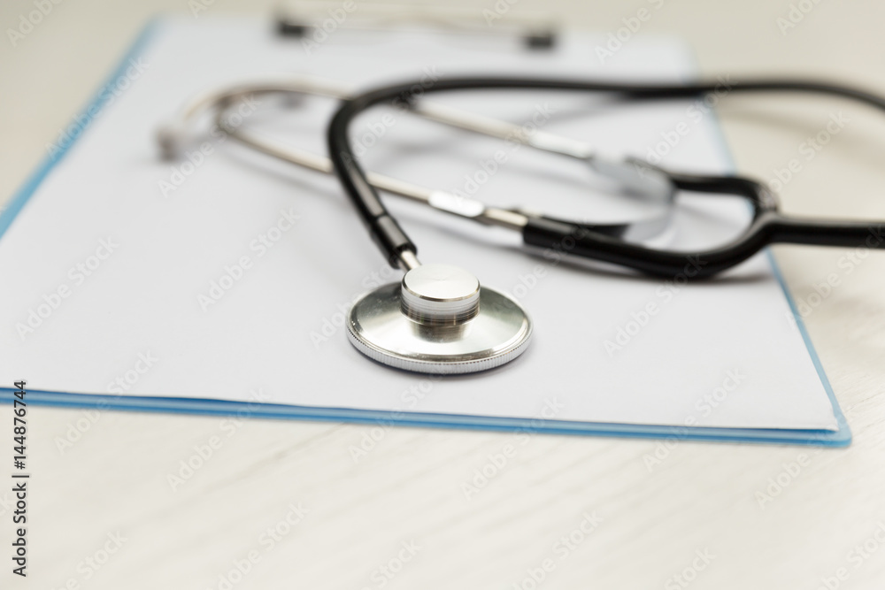 Stethoscope and blue clipboard with a few sheets of paper - medical concept Stethoscope and blue clipboard with a few sheets of paper - medical concept