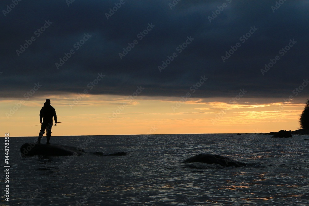 fisher man standing on a rock 