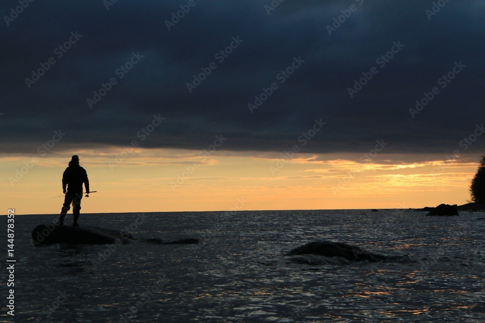 Fototapeta premium fisher man standing on a rock 
