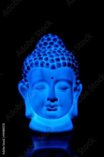 Head of Buddha statue in blue light