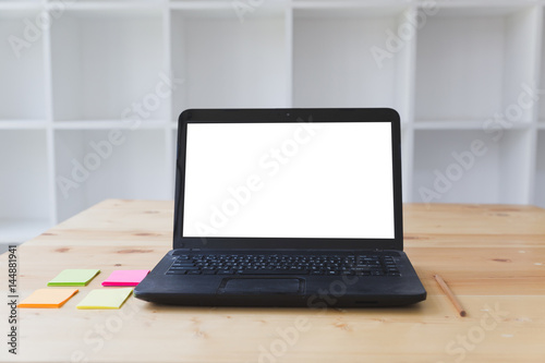 Working at desk with sticky note, pencil and laptop computer