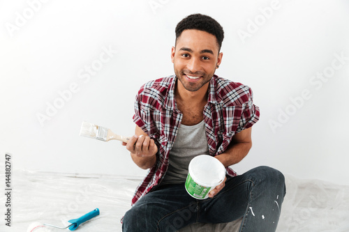 Man sitting on floor with roller isolated photo