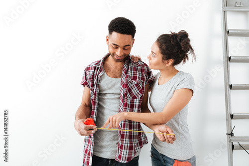 Couple looking at measure tape isolated photo