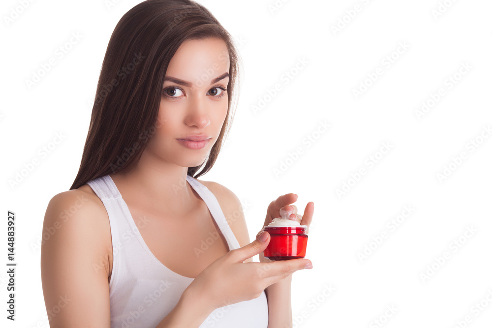 Pretty woman with perfect skin holding a tube with face cream. Young girl with hands on the front. Red jar of cream. Close-up. Isolated background. Beautiful woman wearing a face and hands cream. Pretty woman with perfect skin holding a tube with face cream. Young girl with hands on the front. Red jar of cream. Close-up. Isolated background. Beautiful woman wearing a face and hands cream.