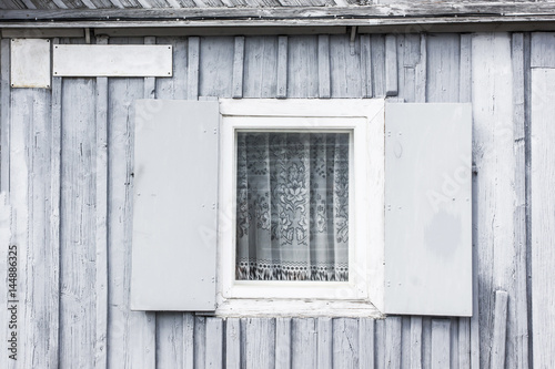 Wooden cottage gray wall with window.