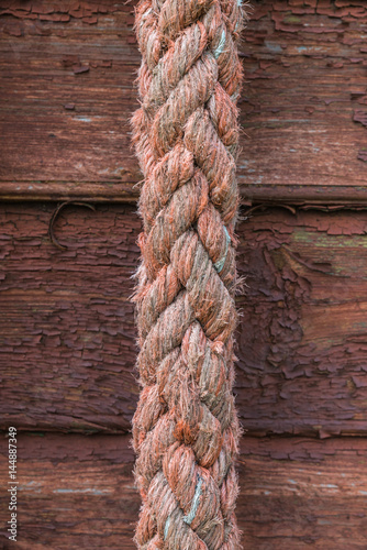 Old red rope on wooden texture