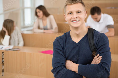 Handsome young male student standing in a classroom