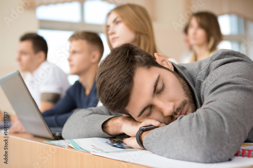 Male university student sleeping in class