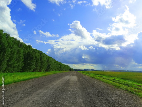 Blue sky with white clouds. The road into the distance.