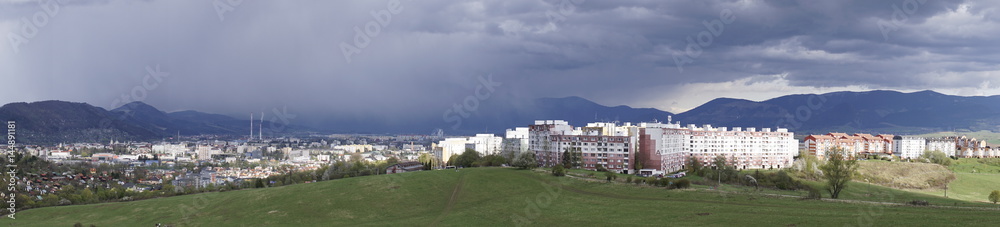 Panorama of rains in distance over mountain and city from meadow on a cloudy day. Slovakia Panorama of rains in distance over mountain and city from meadow on a cloudy day. Slovakia