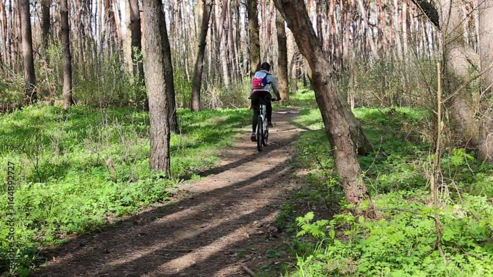 Young woman riding a bicycle in the forest Young woman riding a bicycle in the forest