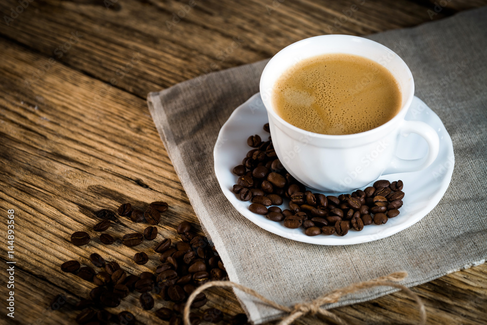 Coffee cup and beans on a wooden table. Coffee cup and beans on a wooden table.