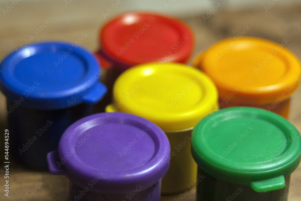 Bright children's paints in jars. Drawing as a hobby or profession Bright children's paints in jars. Drawing as a hobby or profession