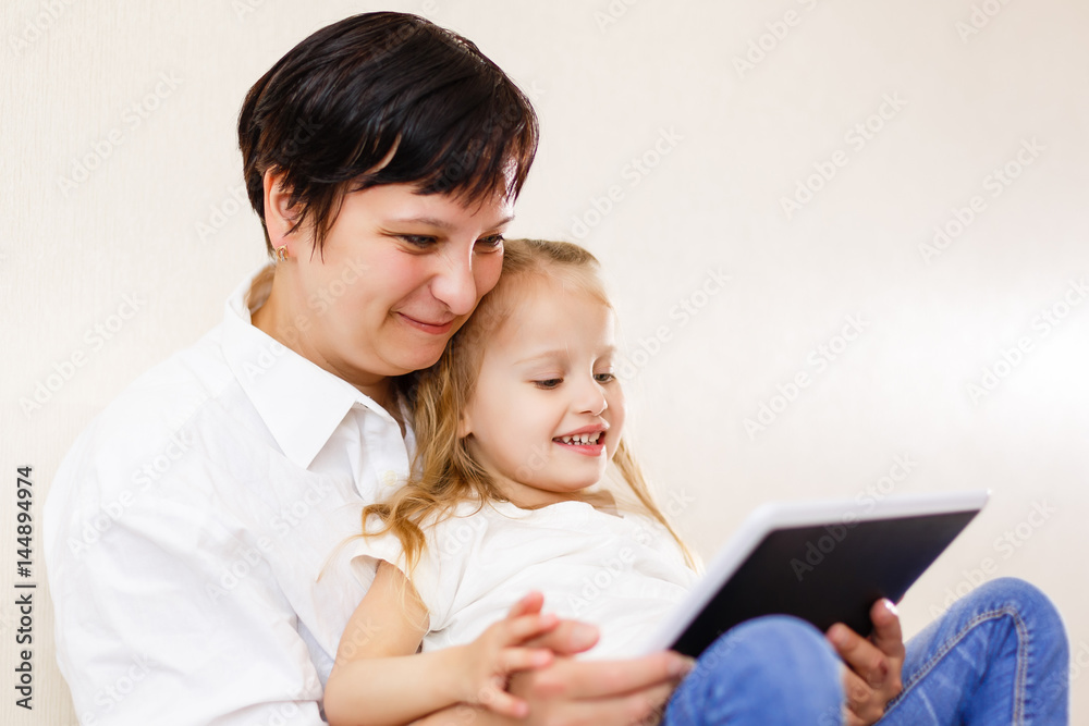 Mom and daughter using tablet Mother and daughter using tablet computer together Mom and daughter using tablet Mother and daughter using tablet computer together