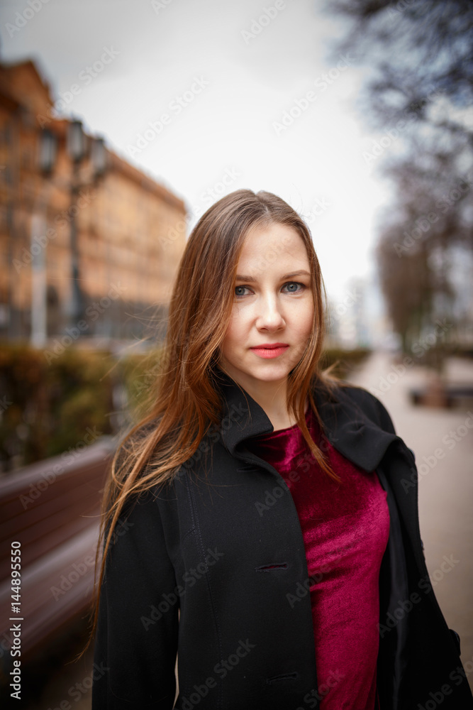 Outdoors portrait young brunette woman posing on a city street. Outdoors portrait young brunette woman posing on a city street.