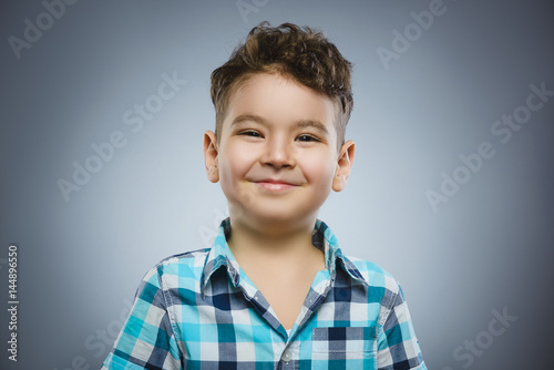 Happy child. Portrait of handsome boy smiling isolated on grey background