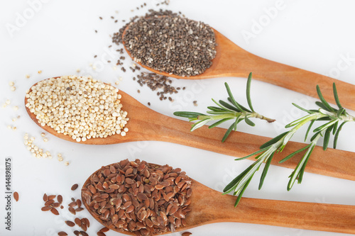 Healthy dried seed used as ingredients in cooking. Linseed  chia and quinoa in wooden spoons.