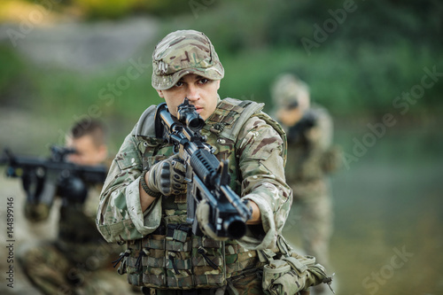 Special forces soldiers with weapon take part in military maneuver. war, army, technology and people concept.