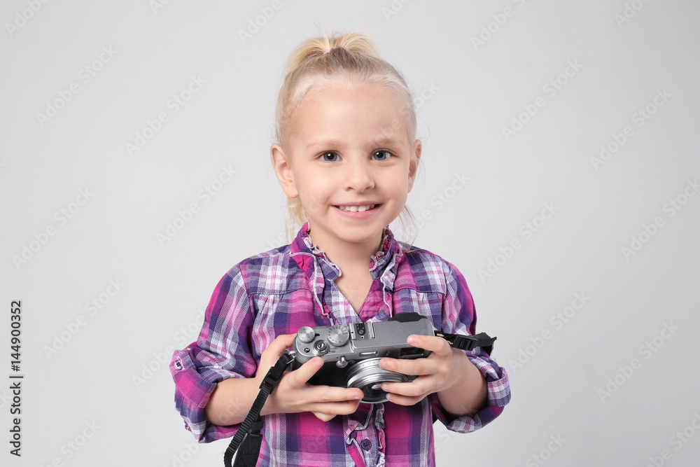 Cute girl with film camera on light background Cute girl with film camera on light background