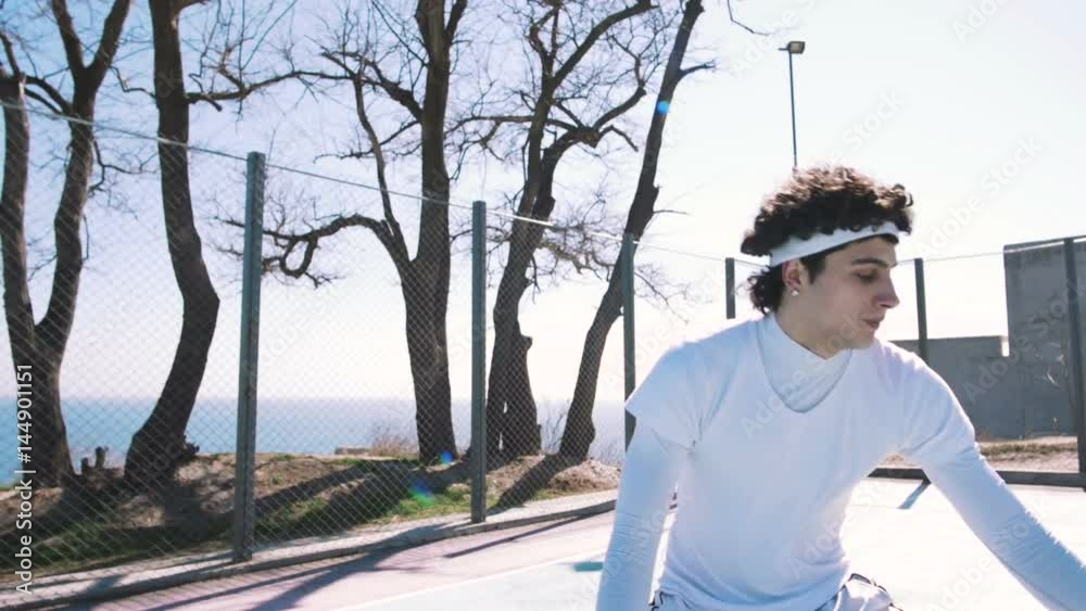 Portrait of a basketball player dribbling the ball with skill on an outdoor basketball court