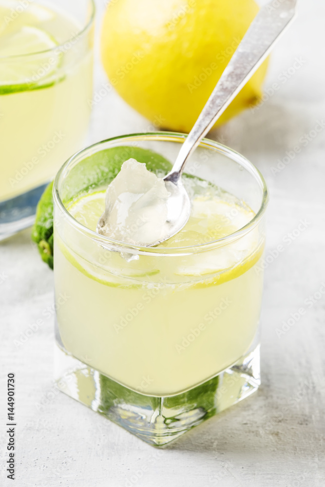 Jelly with lemon and lime in a glass, gray background, selective focus Jelly with lemon and lime in a glass, gray background, selective focus