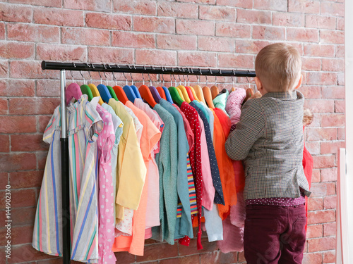 Cute little boy choosing cl...