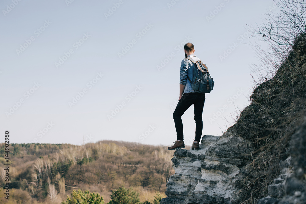 bearded hipster man hiker on a top of a mountain. travel concept