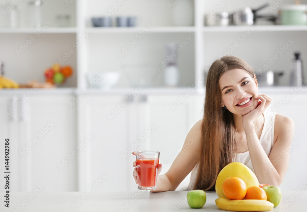 Young woman tasting fresh juice at kitchen Young woman tasting fresh juice at kitchen