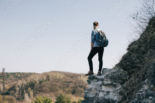 bearded hipster man hiker on a top of a mountain. travel concept