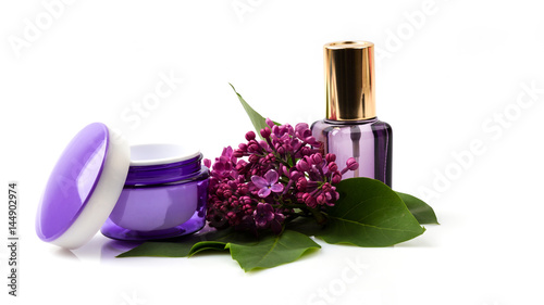 Cosmetic face care products and lilac flowers isolated on white background. Cream, fluid, serum. 