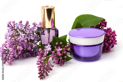 Cosmetic face care products and lilac flowers isolated on white background. Cream, fluid, serum. 