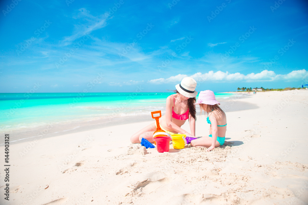 Mom and little cute baby making sandcastle at tropical beach Mom and little cute baby making sandcastle at tropical beach
