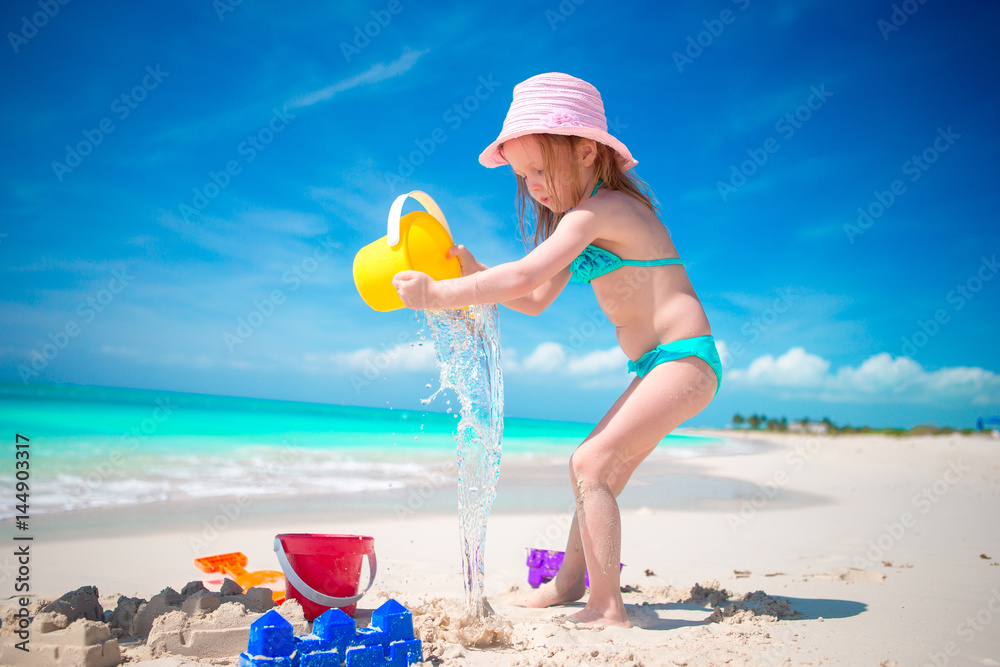 Adorable little girl playing with beach toys on beach Adorable little girl playing with beach toys on beach