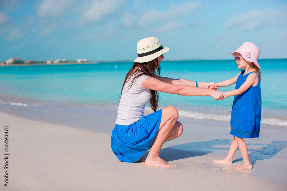Little adorable girl and young mother at tropical beach Little adorable girl and young mother at tropical beach